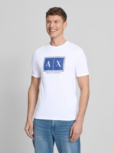 Männermodel trägt T-Shirt mit Logo und Rundhalsausschnitt von ARMANI EXCHANGE in Weiß, Reine Baumwolle, Regular-Fit, Ganzkörperansicht von vorne.