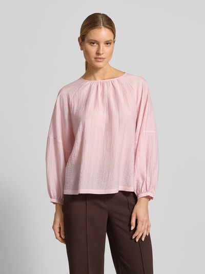 Modelka kobieca nosi Blusenshirt mit Raglanärmeln Modell 'Fibiza' od OPUS, lyocell-mix, luźny krój, okrągły dekolt, różowy, tekstura lekko marszczona, długość tyłu w rozmiarze 36: 59 cm, długość rękawa w rozmiarze 36: 66 cm, widok całej sylwetki z przodu.