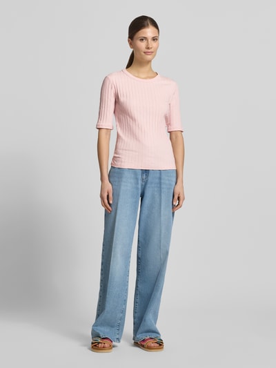 Frauenmodel trägt T-Shirt in Ripp-Optik Modell 'Savka' von OPUS in zartem Rosa, kombiniert mit Jeans; Material-Mix mit Stretch, Slim Fit, Kurzarm, Rundhalsausschnitt, Ganzkörperansicht von vorne.
