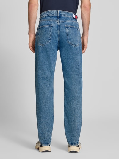 Męski model nosi Slim Straight Fit Jeans aus Baumwoll-Mix Modell 'RYAN' von Tommy Jeans, niebieski denim, tekstura gładka, całkowity widok od tyłu, kontekst: męska bomberka / bluzon od Tommy Jeans.