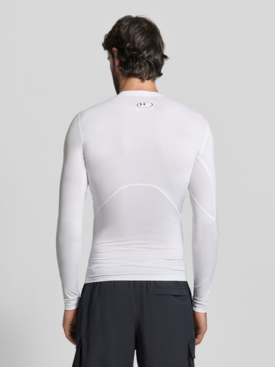 Männermodel draagt Slim Fit Longsleeve met logo-print van Under Armour, wit, elastische materiaalmix, slim fit, rugaanzicht, ruglengte maat M 64 cm.