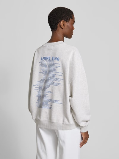 Frauenmodel trägt Relaxed Fit Sweatshirt mit Logo-Print von Anine Bing aus reiner Baumwolle in Hellgrau mit Rundhalsausschnitt und elastischen Abschlüssen, Rückenansicht Ganzkörperansicht.