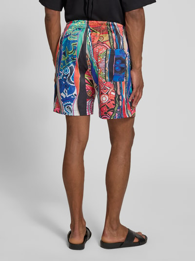 Männermodel trägt Straight Fit Shorts mit elastischem Bund Modell 'Resort' von COLUCCI, bunt gemustert, Ganzkörperansicht Rückansicht. Herren Shorts aus elastischem Material-Mix, Produktdetails: Bundweite 39 cm, Innenbeinlänge 16 cm bei Größe M.