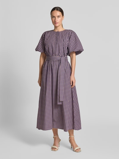 Frauenmodel trägt Midikleid im Allover-Look mit Bindegürtel von Rich & Royal in Lila mit Muster aus reiner Baumwolle, Ganzkörperansicht von vorne.