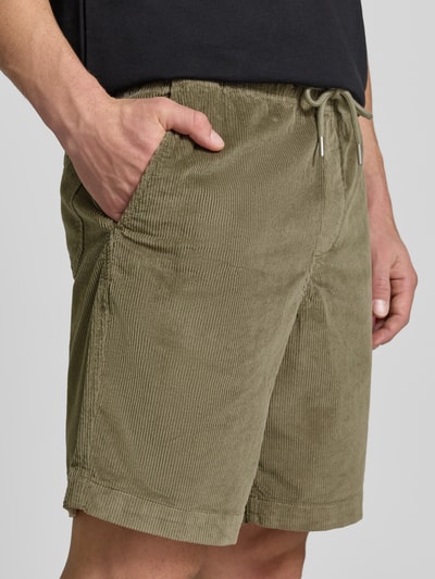 Mężczyzna nosi Regular Fit Sweatshorts aus Baumwoll-Mix von SELECTED HOMME, zielony sztruks, kieszenie boczne, gumka w pasie, widok z przodu, zbliżenie na górną część ciała.