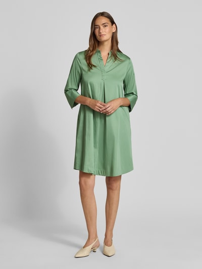 Frauenmodel trägt A-Linie Freizeitkleid aus Baumwoll-Mix von s.Oliver BLACK LABEL in hellem Grün mit glatter Struktur, Ganzkörperansicht von vorne.