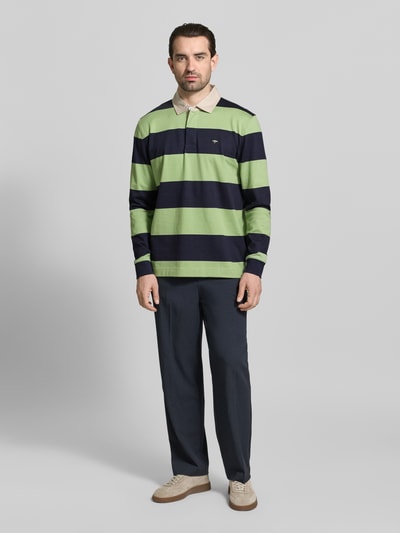 Männermodel trägt Regular Fit Poloshirt mit Streifenmuster und Label-Stitching von Fynch-Hatton, grün-blau gestreift, Baumwolle, Ganzkörperansicht von vorne.