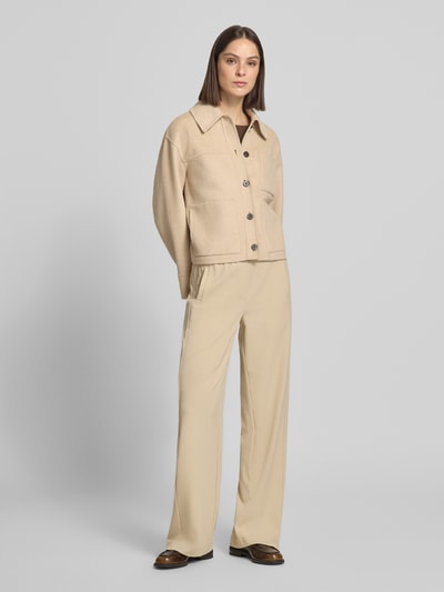 Frauenmodel trägt Jacke mit aufgesetzten Taschen Modell 'Helia' von OPUS in Beige, Baumwoll-Mix, entspannter Schnitt, Ganzkörperansicht von vorne.