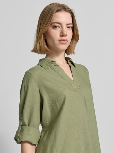 Modelka nosi Relaxed Fit Hemdbluse aus Leinen-Viskose-Mix od s.Oliver RED LABEL w kolorze oliwkowym, jednolitym, długi rękaw z możliwością podwinięcia, materiał flammgarn, widoczny kołnierz koszulowy, dekolt w serek, perspektywa: zbliżenie na górną część ciała z przodu.