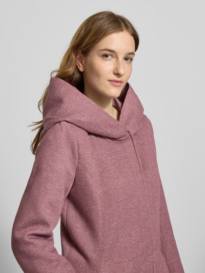 Frauenmodel trägt Taillierter Mantel mit Kapuze Modell 'SEDONA' von Only in unifarbener Melange-Optik mit langen Ärmeln, Nahaufnahme Oberkörper.