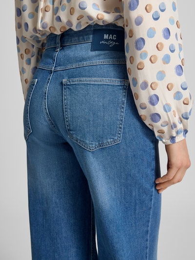Frauenmodel trägt Flared Fit Jeans im 5-Pocket-Design von MAC aus elastischem Baumwoll-Mix in Mittelblau, Detailaufnahme Rückansicht.