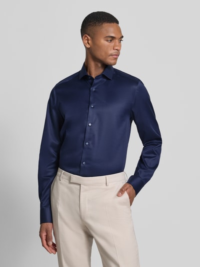 Męski model nosi Slim Fit Business-Hemd in unifarbenem Design mit Kentkragen von OLYMP Level Five z bawełny, jednokolorowy, krój slim fit, kołnierzyk typu kent, listwa guzikowa, długość tyłu w rozmiarze 40: 81 cm, szerokość ramion w rozmiarze 40: 44 cm, długość rękawów w rozmiarze 40: 68 cm, widok całej sylwetki z przodu.