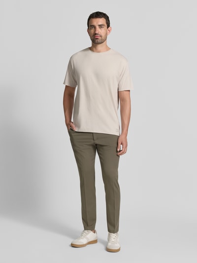 Männermodel trägt T-Shirt mit Rundhalsausschnitt und Rollsaum von Scotch & Soda aus reiner Baumwolle, Relaxed Fit, Ganzkörperansicht von vorne