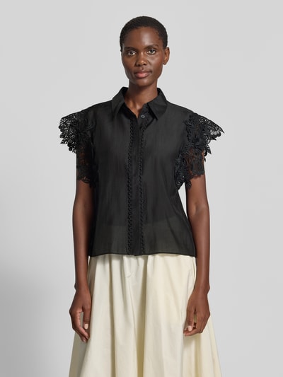 Frauenmodel trägt Regular Fit Bluse mit Spitzenbesatz Modell 'MOLLY' von Copenhagen Muse, Material-Mix mit Stretch-Anteil, Hemdblusenkragen, verdeckte Knopfleiste, Schwarz mit Texturkontrast, Ganzkörperansicht von vorne. Rückenlänge bei Größe S: 62 cm, Ärmellänge bei Größe S: 10 cm.