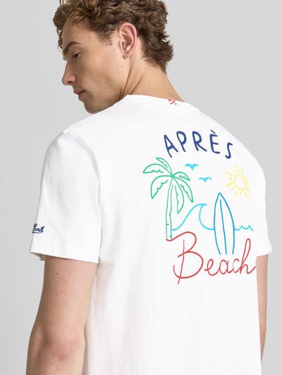 Männermodel trägt T-Shirt mit Label-Prints Modell 'PORTLAND' von MC2 Saint Barth aus reiner Baumwolle in Weiß, Regular-Fit, Label-Stitching am Ärmel, bunte Motiv-Prints auf Rückseite, Rundhalsausschnitt, Rückenlänge 67 cm bei Größe M, Nahaufnahme Oberkörper Rückansicht.