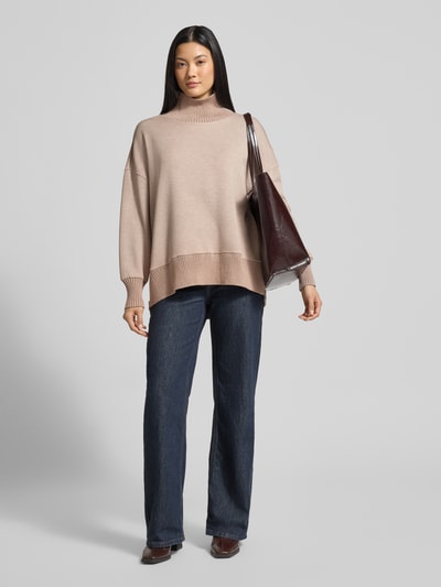 Kobiece modelka nosi bluzę Sweatshirt mit Stehkragen und überschnittenen Schultern od VARLEY, mieszanka wiskozy z dodatkiem streczu, krój relaxed fit, stójka, obniżone ramiona, jasnobeżowa z kontrastowym ściągaczem, pełny widok z przodu.