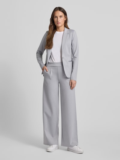 Vrouwenmodel draagt Wide Fit Stoffhose mit Viskose-Anteil Modell 'Kate' van ICHI in lichtgrijs met wijde pijpen en elastische tailleband, Ganzkörperaanzicht van voren.