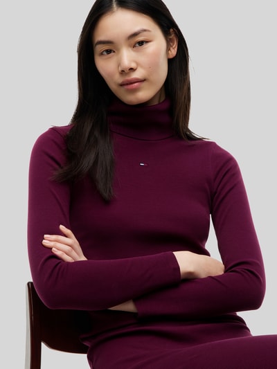 Frauenmodel trägt Eng anliegendes Freizeitkleid aus Baumwoll-Mix von Tommy Jeans in Dunkellila mit feiner Struktur, Nahaufnahme Oberkörper.
