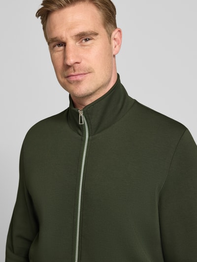 Männermodel trägt Sweatjacke mit Stehkragen und Eingrifftaschen von PAUL SMITH aus Baumwoll-Mix mit Modal-Anteil, Nahaufnahme Oberkörper.
