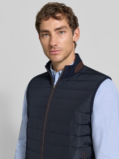 Männermodel trägt Steppweste mit Stehkragen und Eingrifftaschen von bugatti, Baumwoll-Mix, Reißverschluss, Nahaufnahme Oberkörper.