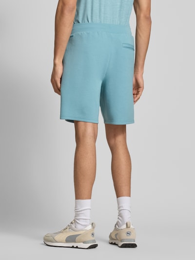Männermodel trägt Straight Fit Shorts mit Lyocell-Anteil Modell 'Cloudspun' von PUMA PERFORMANCE in Hellblau, Rückansicht, Ganzkörperansicht. Elastischer Bund mit Tunnelzug, Gesäßtasche und Logo-Detail, elastischer Material-Mix, matte Textur.