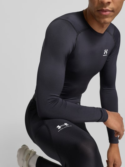 Männermodel trägt Leggings mit Beintasche von Under Armour in Schwarz, Elastischer-Material-Mix, Label-Print, Eng anliegende Passform, Nahaufnahme Oberkörper.