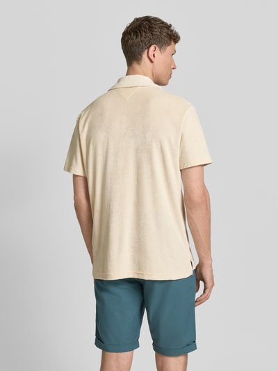 Männermodel trägt Regular Fit Poloshirt aus Frottee von Tommy Hilfiger in Beige mit Polokragen, Label Stitching, Rückansicht Ganzkörperansicht.