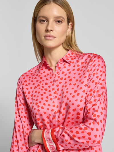 Vrouwenmodel draagt Regular Fit Blouse uit viscose in all-over look van Milano Italy, roze met rode stippen, knoopsluiting, overhemdkraag, ruglengte 66 cm, mouwlengte 61 cm, detailopname bovenlichaam.