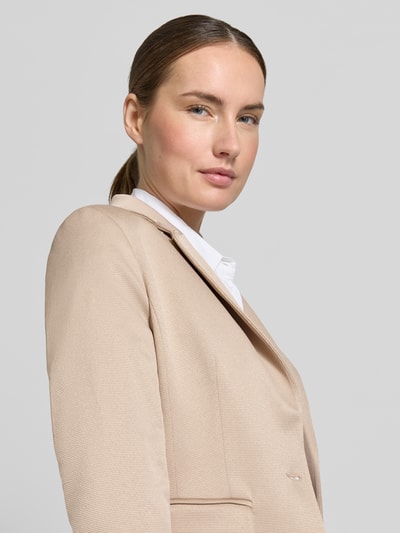 Frauenmodel trägt Regular Fit Blazer mit Pattentaschen von More & More in Beige mit Reverskragen und Knopfverschluss, Nahaufnahme Oberkörper.