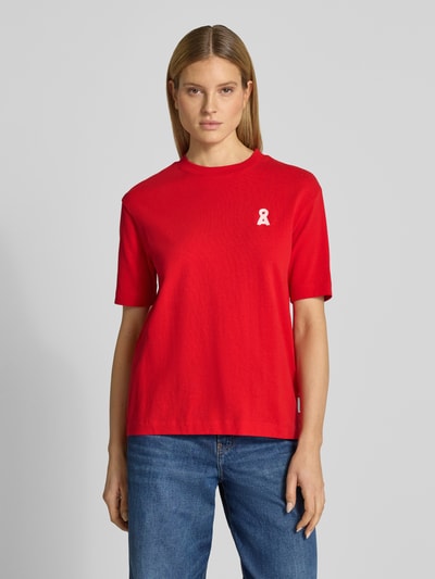 Modelka nosi damski t-shirt Loose Fit T-Shirt aus reiner Baumwolle Modell 'ICONIC A TARJAA' od Armedangels, efekt: jednolity kolor, wyhaftowane logo, okrągły dekolt, krótki rękaw, drobne prążkowanie, bawełna, widok z przodu na całą sylwetkę.