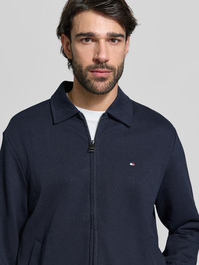 Männermodel trägt Regular Fit Sweatjacke aus reiner Baumwolle von Tommy Hilfiger, Optik: Unifarben, Nahaufnahme Oberkörper.
