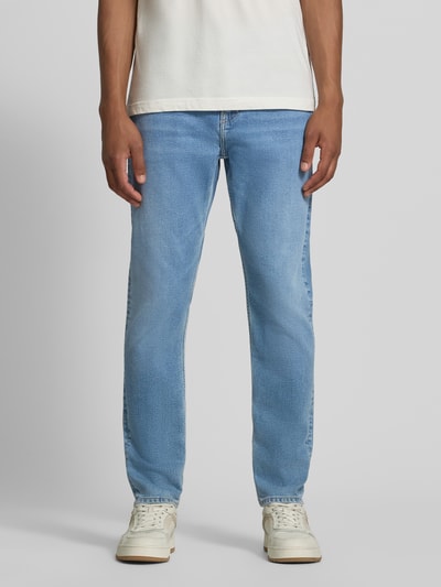 Männermodel trägt hellblaue Tapered Fit Jeans aus Baumwoll-Lyocell-Mix Modell 'AARJO TARPA' von ARMEDANGELS, Herren Tapered Fit Jeans, Ganzkörperansicht von vorne.