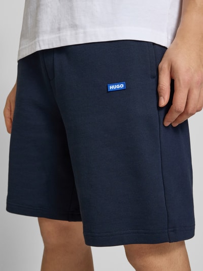 Männermodel trägt Regular Fit Sweatshorts aus reiner Baumwolle Modell 'NASENSIO' von Hugo Blue, Optik: Unifarben, Nahaufnahme Oberkörper