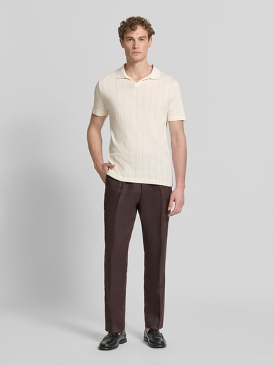 Męski model nosi Regular Fit Poloshirt in Jaquard-Strick von Lindbergh z czystej bawełny, kołnierzyk polo, dekolt w serek, detal z logo, długość tyłu w rozmiarze M: 73 cm, widok całej sylwetki z przodu