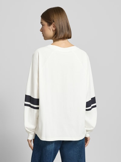 Kobiece modelka nosi Loose Fit Langarmshirt aus reiner Baumwolle od Marc O'Polo Denim, jednokolorowy efekt, paski w kontrastowym kolorze, nadruk z logo, okrągły dekolt, rękawy długie z prążkowanym wykończeniem, czysta bawełna, widok całej sylwetki z tyłu.
