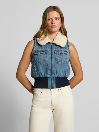 Frauenmodel trägt Regular Fit Weste aus reiner Baumwolle Modell 'TINY SHERPA VEST' von Levi's®, blau mit weißem Kragen, Damen Weste, Ganzkörperansicht von vorne.