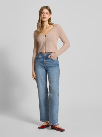 Frauenmodel trägt Slim Fit Strickjacke mit einreihige Knopfleiste Modell 'KERRY' von Only, Optik: Unifarben, V-Ausschnitt, Langarm, Strick, Label Patch, gerippte Abschlüsse, Ganzkörperansicht von vorne.