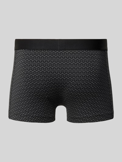 Männermodel trägt Trunks aus Baumwoll-Mix im 3er-Pack von BOSS in Schwarz mit feinem geometrischem Muster, elastischer Label-Bund, Ganzkörperansicht Rückansicht.