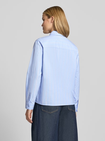 Frauenmodel trägt Regular Fit Hemdbluse aus reiner Baumwolle von Christian Berg Woman in Hellblau mit weißen Streifen, Rückansicht, Detailaufnahme. Reines Baumwollmaterial, Hemdblusenkragen, Brusttasche, langärmelig, Rückenlänge 62 cm, Ärmellänge 60 cm.