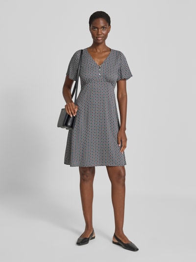 Modelka kobieca nosi Knielanges Kleid aus Viskose mit V-Ausschnitt von zero, wzór geometryczny, taliowany krój, długość do kolan, dekolt w serek, krótka listwa guzikowa, wiązany pasek, Długość tyłu w rozmiarze 36: 90 cm, Szerokość w rozmiarze 36: 32 cm, Długość rękawów w rozmiarze 36: 21 cm, cała sylwetka z przodu.