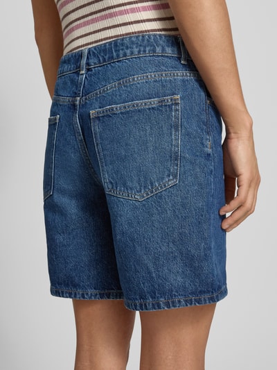 Frauenmodel trägt Jeansshorts mit Eingrifftaschen von REVIEW, Reine Baumwolle, Regular-Fit, mittleres Blau, Ganzkörperansicht Rückansicht.