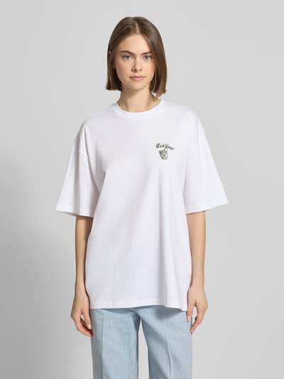 Frauenmodel trägt Oversized T-Shirt mit Statement-Print von REVIEW aus Reine Baumwolle, Oversize Fit, Rundhalsausschnitt, Rückenlänge bei Größe S 70 cm, weiß mit weicher Textur, Ganzkörperansicht von vorne.
