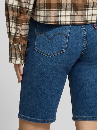 Frauenmodel trägt Regular Fit Bermuda in Denim-Optik von Levi’s®, elastischer Baumwoll-Mix, 5-Pocket-Design, Nahaufnahme Rückansicht.