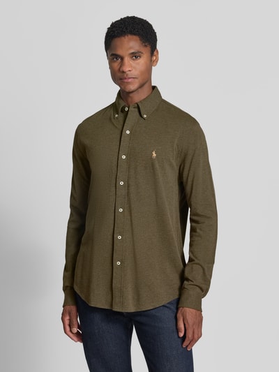 Męski model nosi Regular Fit Freizeithemd aus reiner Baumwolle von Polo Ralph Lauren, oliwkowozielona koszula casualowa, prosta faktura, widok z przodu na całą sylwetkę.