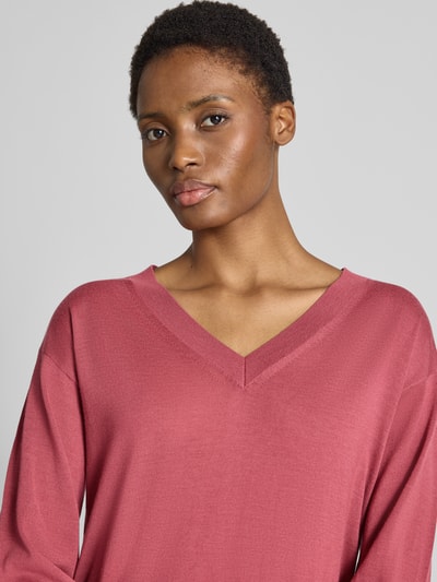 Kobieta nosi Regular Fit Pullover aus reiner Schurwolle model 'Freeslyn' od BOSS w kolorze różowym, delikatna tekstura, kontekst: damski sweter BOSS, zbliżenie górnej części ciała.