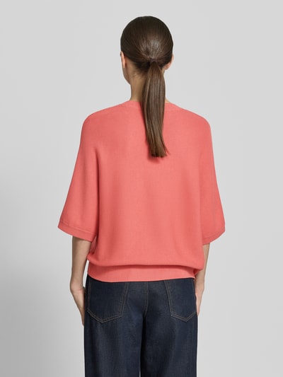Modelka prezentuje sweter z dzianiny z mieszanka wiskozy 'Strickpullover aus Viskose-Mix mit Rundhalsausschnitt' od MSCH Copenhagen, krój loose fit, prążkowany okrągły dekolt, rękaw o dł. 3/4, prążkowane wykończenia, długość tyłu 51 cm, długość rękawów 35 cm, widok całej sylwetki z tyłu.
