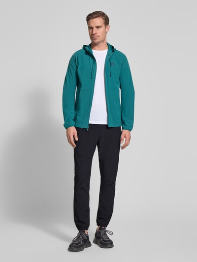 Männermodel trägt Regular Fit Sweatpants mit Logo-Print Modell 'Vibe' von Under Armour, Schwarz, Elastischer-Material-Mix, Ganzkörperansicht von vorne.