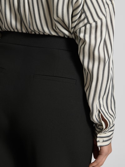 Frauenmodel trägt Wide Fit Schlupfhose mit Viskose-Anteil Modell 'Palina' von Raffaello Rossi, schwarze Crêpe-Struktur, Nahaufnahme Rückansicht.