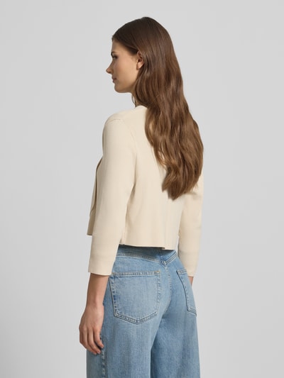 Vrouwenmodel draagt Strickjacke in offener Passform mit 3/4-Arm van comma, viscosemix in crème, ruglengte 44 cm, mouwlengte 45 cm, geheelbeeld achteraan.
