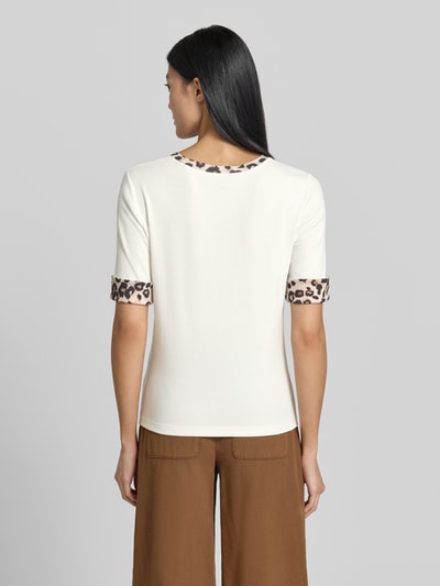 Frauenmodel trägt Regular Fit T-Shirt mit Animal-Print von Marc Cain aus elastischem Baumwoll-Mix, Halbarm, weiß mit braunen Details, Ganzkörperansicht Rückansicht.
